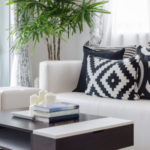 white sofa with geometric print pillows and dark wood table